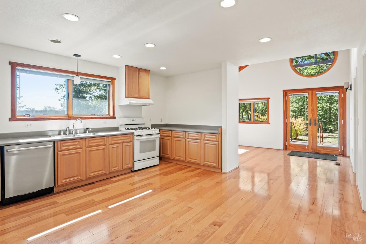 10185 East Road Redwood Valley, CA 95470 - Photo 6 of 17 a kitchen with granite countertop a stove a sink and white cabinets with wooden floor