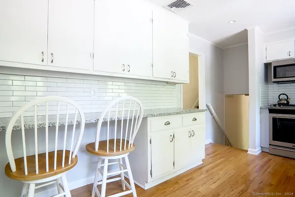 a kitchen with stainless steel appliances a stove a table and chair