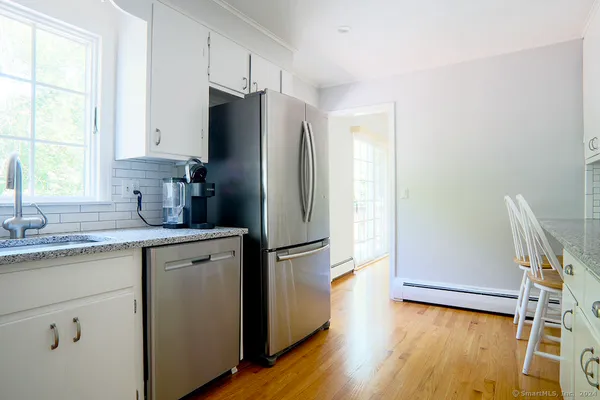 a kitchen with a refrigerator sink and wooden floor