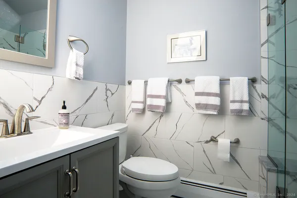 a bathroom with a toilet sink and mirror