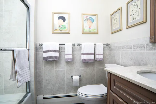 a bathroom with a granite countertop sink a toilet and a mirror