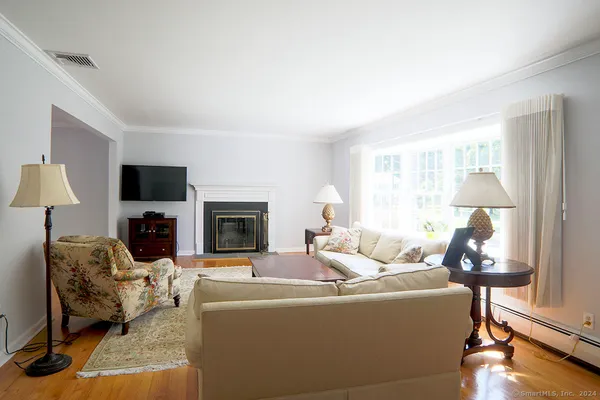 a living room with furniture a flat screen tv and a fireplace