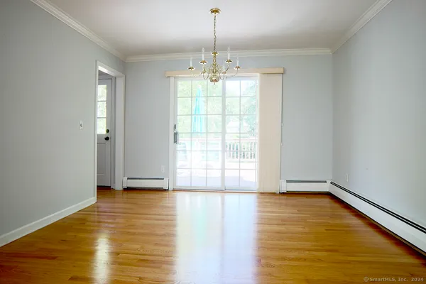 a view of an empty room with window and wooden floor