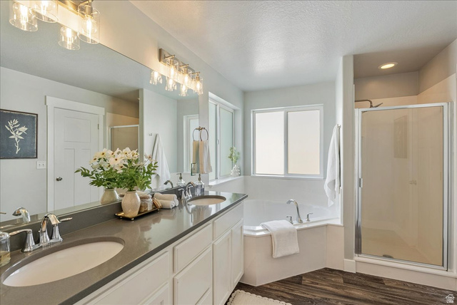 882 Spring Dew Lane Lehi, UT 84048 - Photo 34 of 46 Full bathroom with a shower stall, double vanity, a bath, a textured ceiling, and dark wood-type flooring