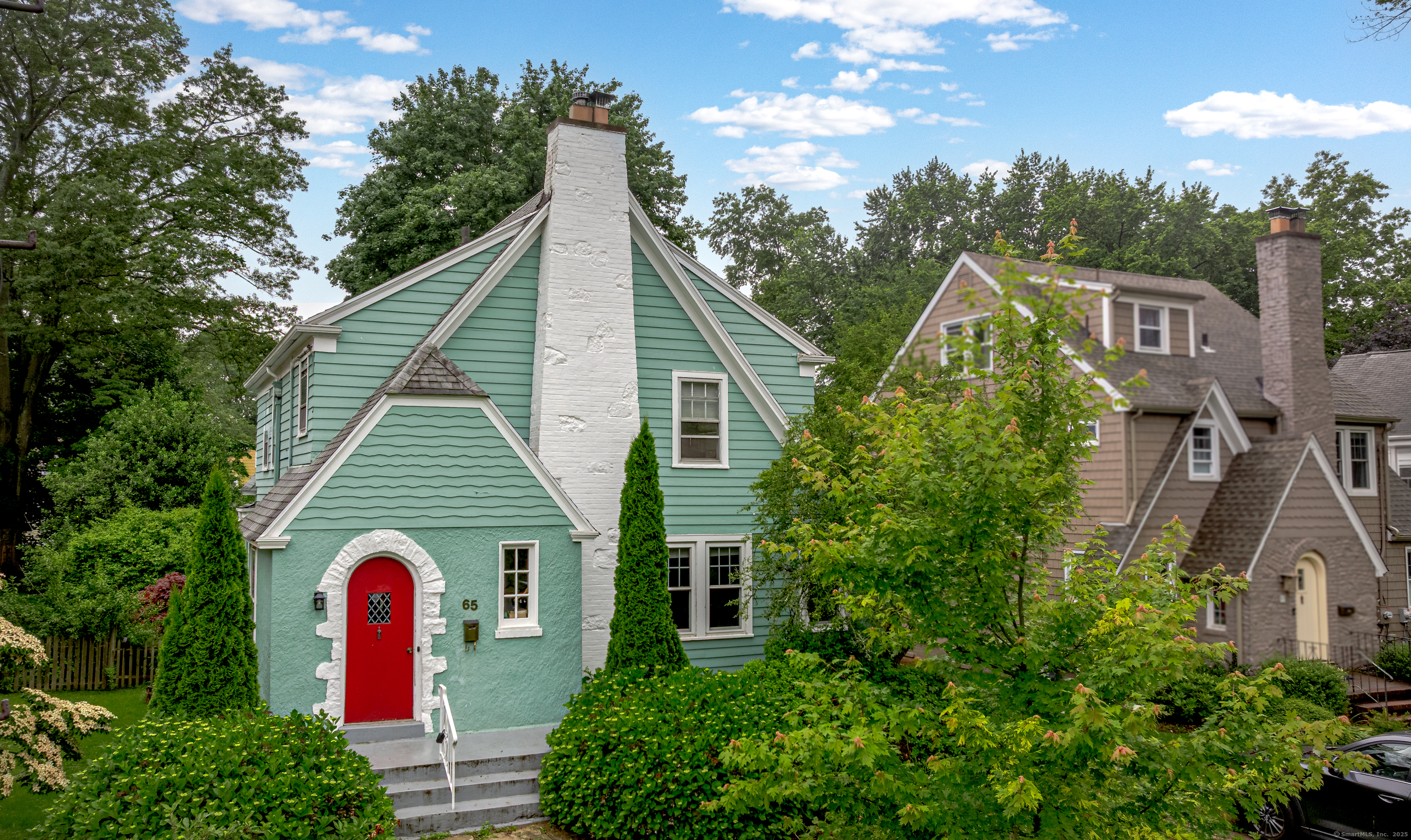 a view of a house with a yard and potted plants