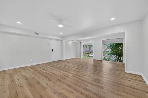 a view of empty room with wooden floor and window