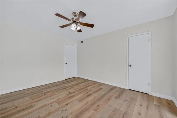 a view of a room with wooden floor and a ceiling fan