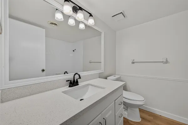 a bathroom with a sink a toilet and shower