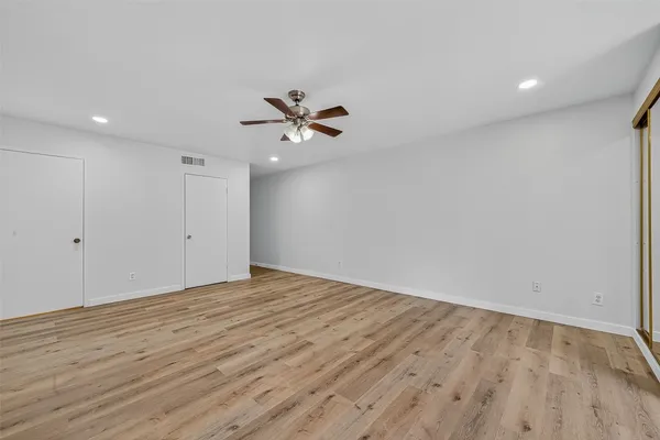 a view of room with hardwood floor and ceiling fan