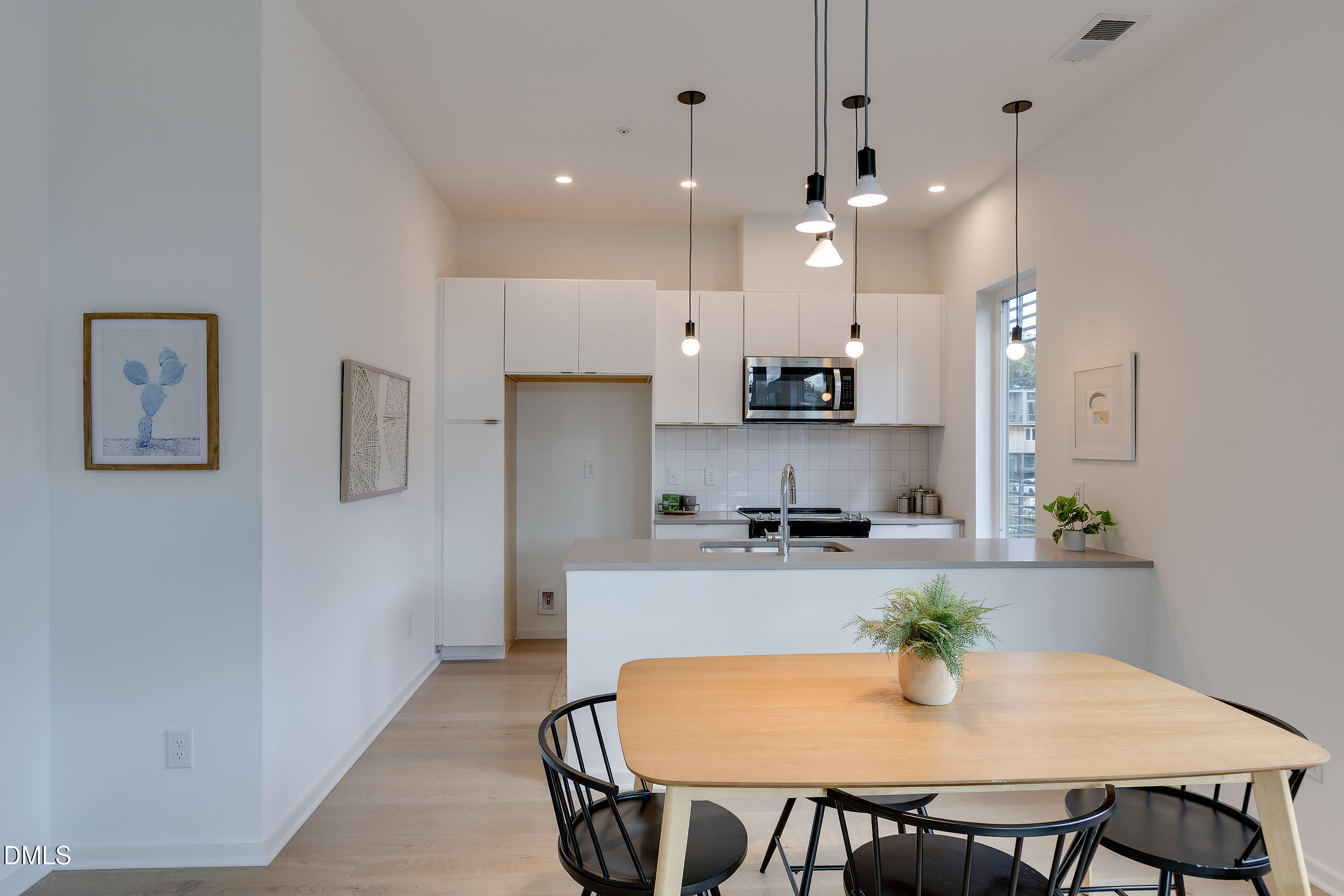521 North Mangum Street, Unit 21 Durham, NC 27701 - Photo 5 of 21 a kitchen with stainless steel appliances a dining table chairs and refrigerator