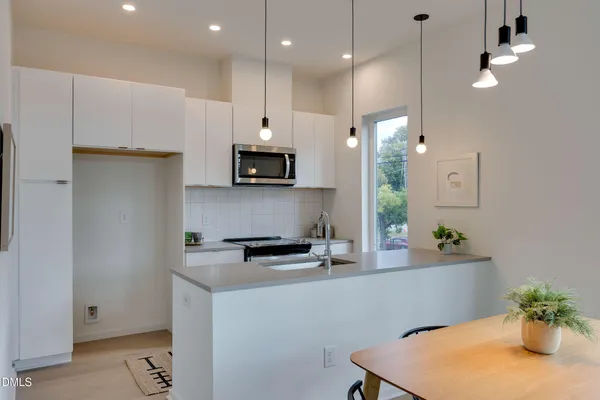 a kitchen with stainless steel appliances kitchen island granite countertop a sink a stove and a refrigerator