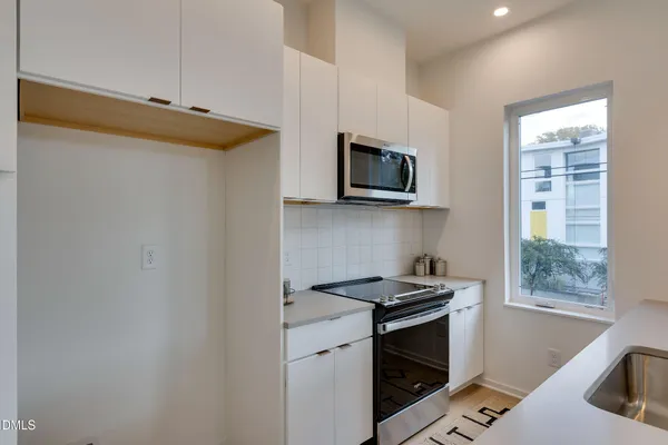 a kitchen with stainless steel appliances a stove microwave and sink