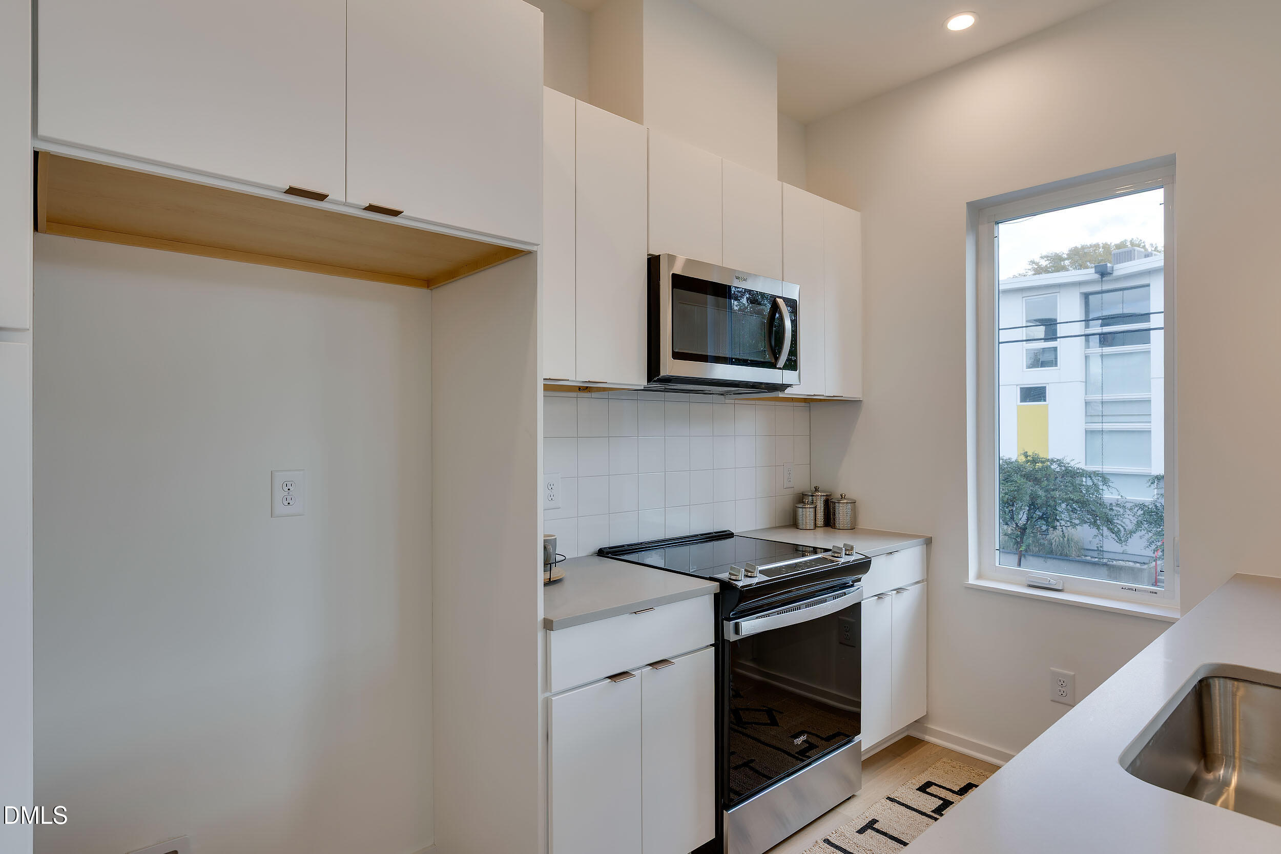 521 North Mangum Street, Unit 21 Durham, NC 27701 - Photo 9 of 21 a kitchen with stainless steel appliances a stove microwave and sink