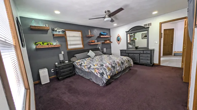 a bedroom with a bed and a flat tv screen on dresser