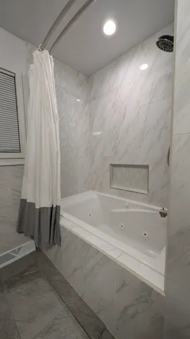 a bathroom with a bathtub and a shower