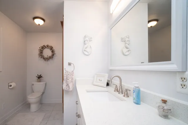 a bathroom with a toilet sink and mirror