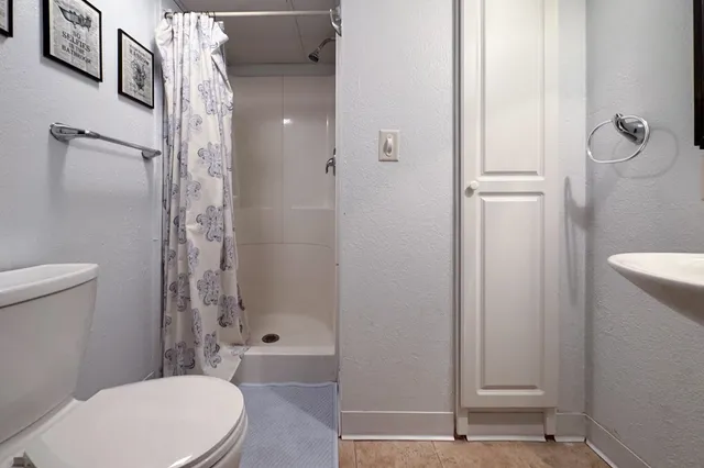 a bathroom with a toilet a sink and shower
