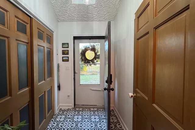 a view of a hallway with wooden floor and a bathroom