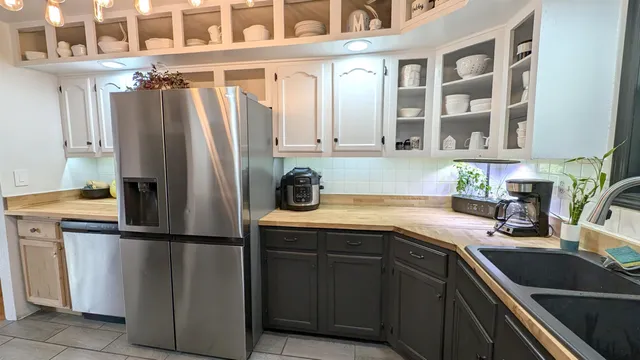 a kitchen with stainless steel appliances granite countertop a refrigerator and a sink
