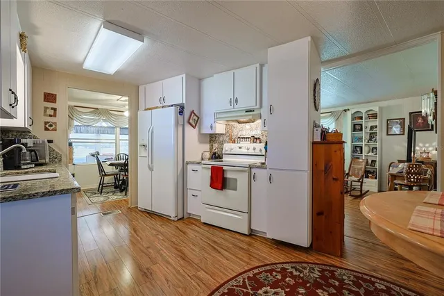 a kitchen with stainless steel appliances granite countertop a sink a stove and cabinets