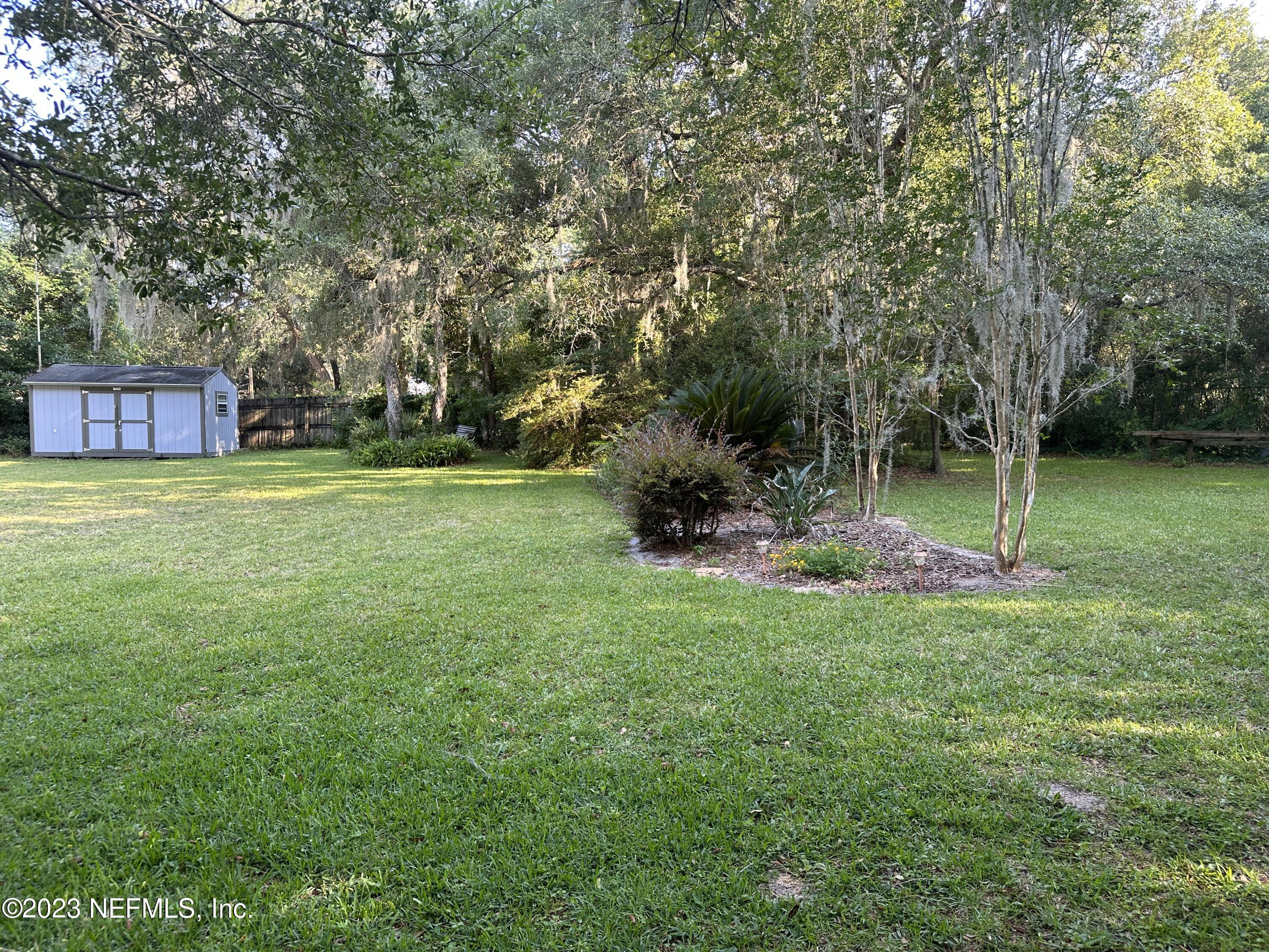2797 Kings Road St. Augustine, FL 32086 - Photo 22 of 24 a backyard of a house with plants and large trees