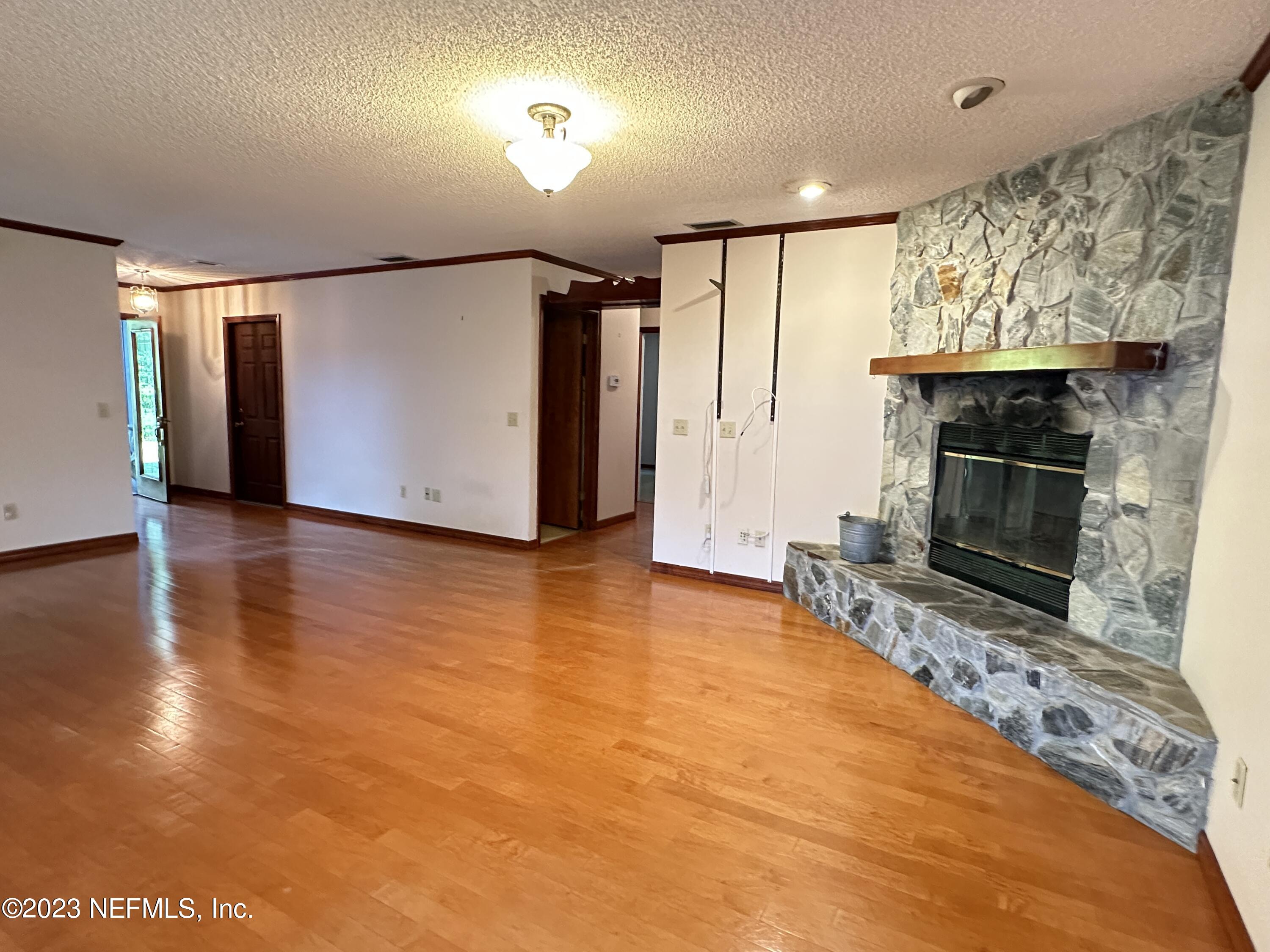 2797 Kings Road St. Augustine, FL 32086 - Photo 7 of 24 a view of an empty room with wooden floor and a fireplace