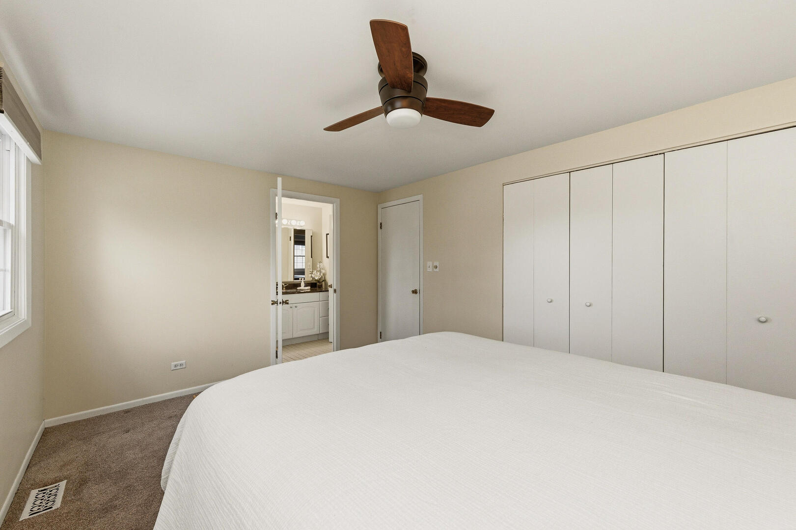 2023 Springside Drive Naperville, IL 60565 - Photo 14 of 16 a bedroom with a large bed and a chandelier fan