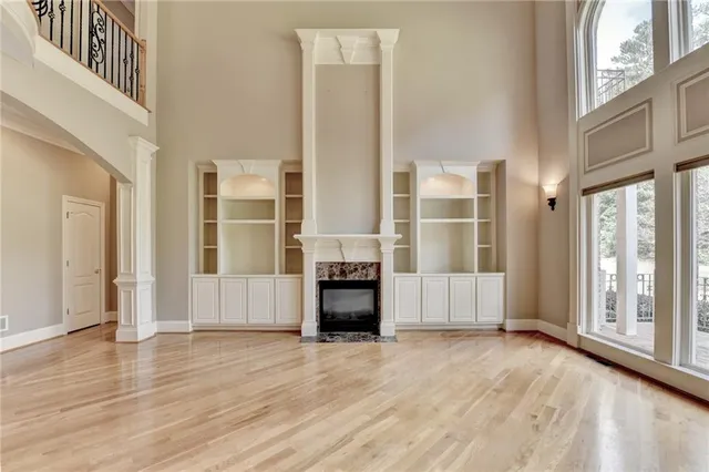a view of an empty room with a window and chandelier