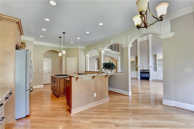 an empty room with a chandelier fan and windows