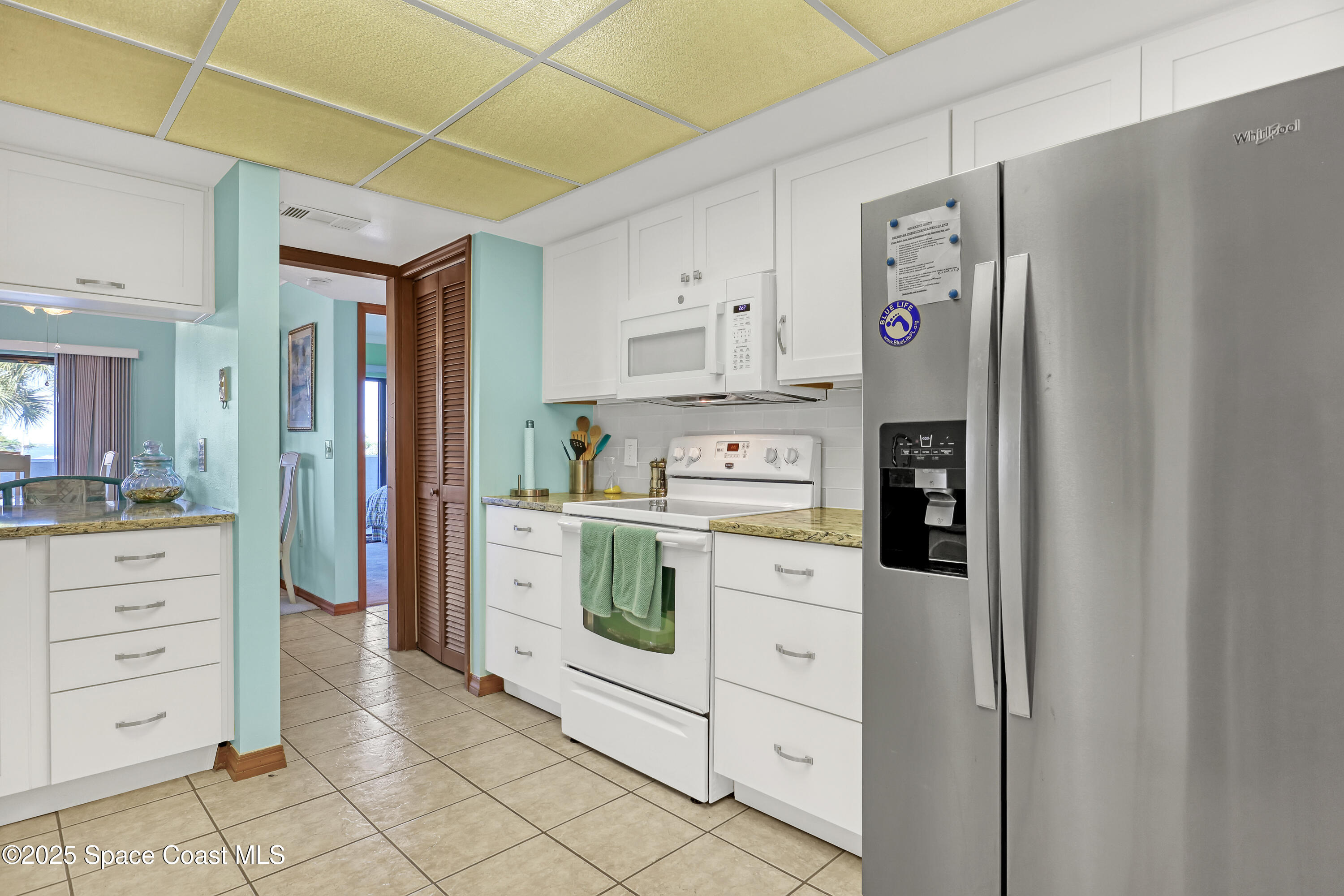5011 Dixie Highway Northeast, Unit A209 Palm Bay, FL 32905 - Photo 20 of 44 a kitchen with white cabinets and refrigerator