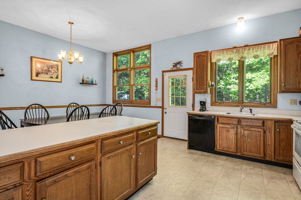 2020 Bay Road Stoughton, MA 02072 - Photo 12 of 38 a spacious kitchen with stainless steel appliances granite countertop a stove a sink dishwasher a dining table and chairs with wooden floor