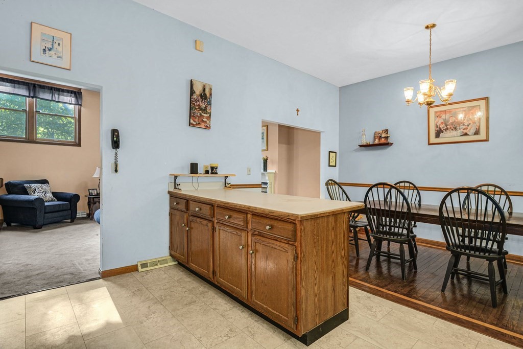 2020 Bay Road Stoughton, MA 02072 - Photo 13 of 38 a kitchen with stainless steel appliances granite countertop a stove a sink a dining table and chairs with wooden floor