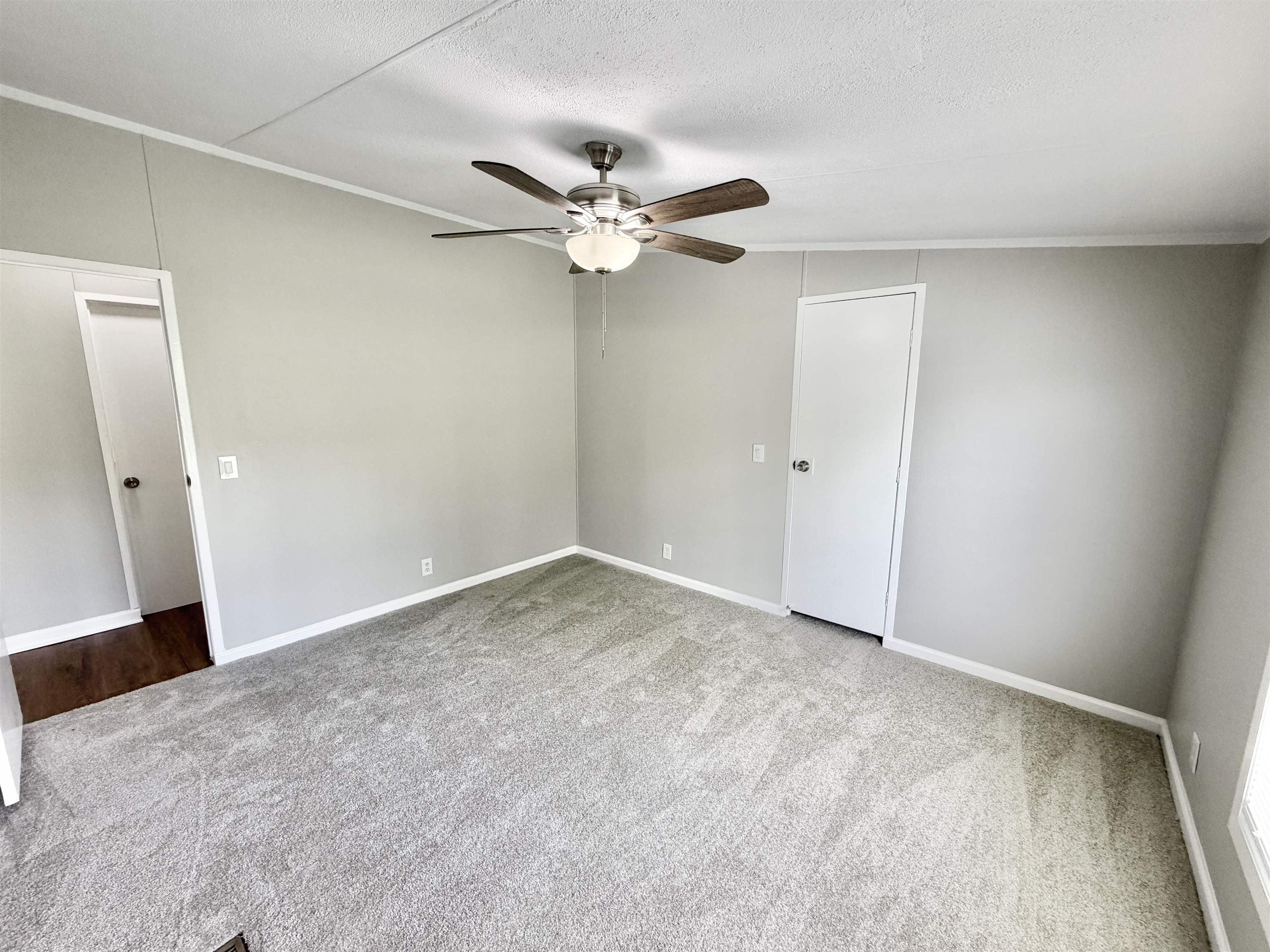 1655 Fayne Road Brighton, TN 38011 - Photo 13 of 28 Spacious room with light gray wall paneling, light gray carpeting, a built-in ceiling fan with integrated lighting, white baseboards, and a white interior door