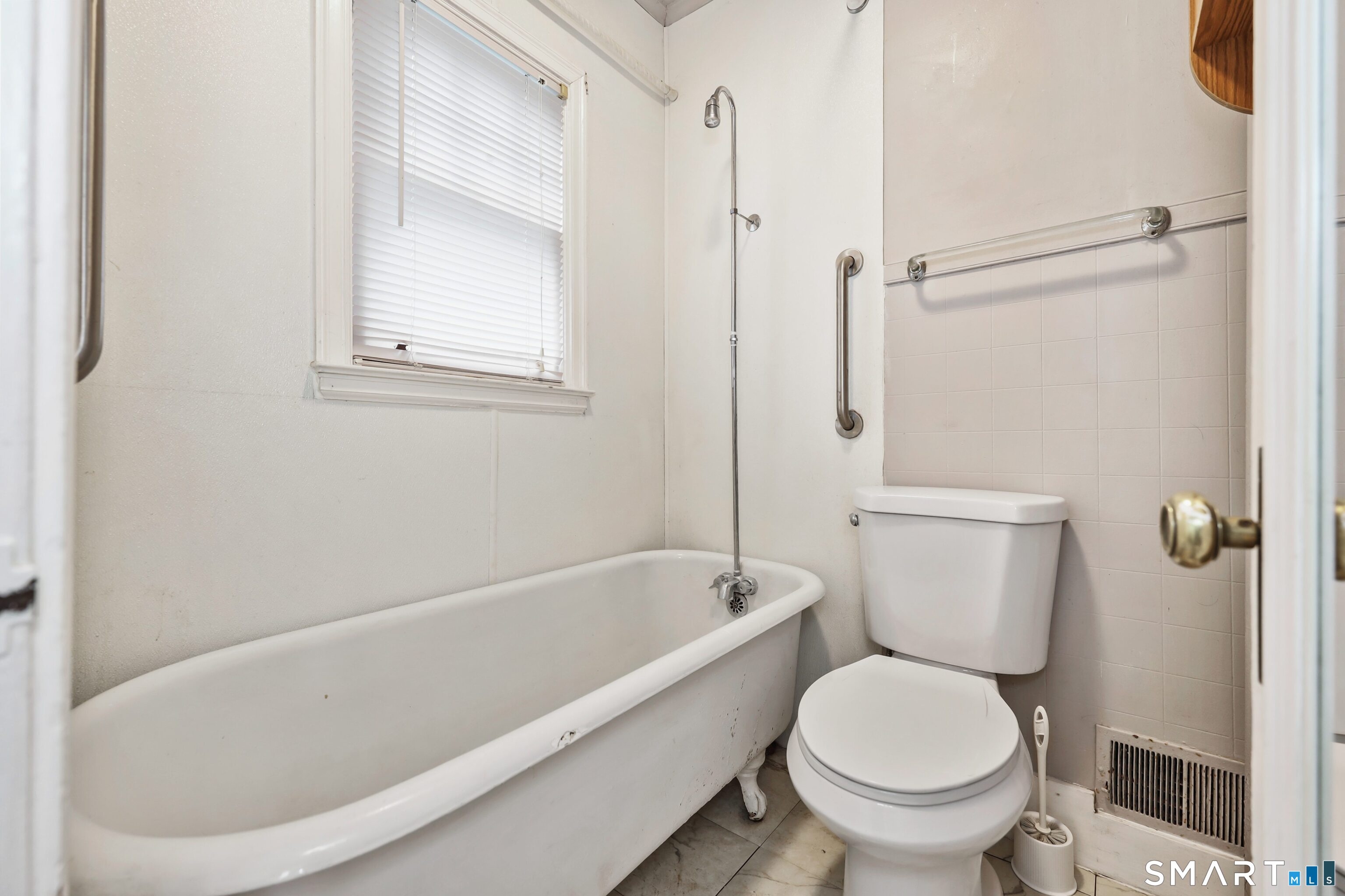 125 Tioga Street Torrington, CT 06790 - Photo 16 of 40 a white toilet sitting next to a bathtub