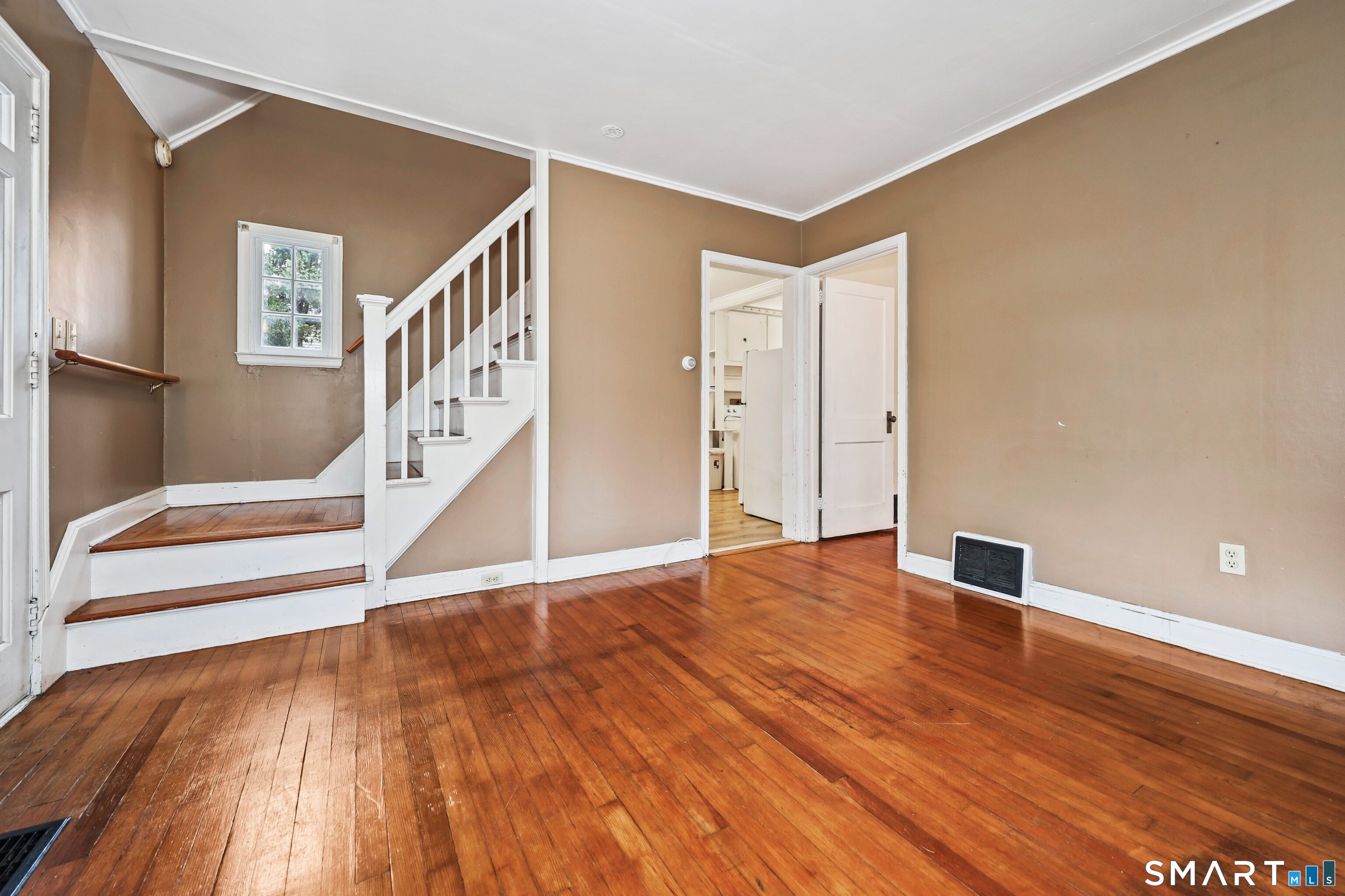 125 Tioga Street Torrington, CT 06790 - Photo 4 of 40 a view of an empty room with stairs and a window