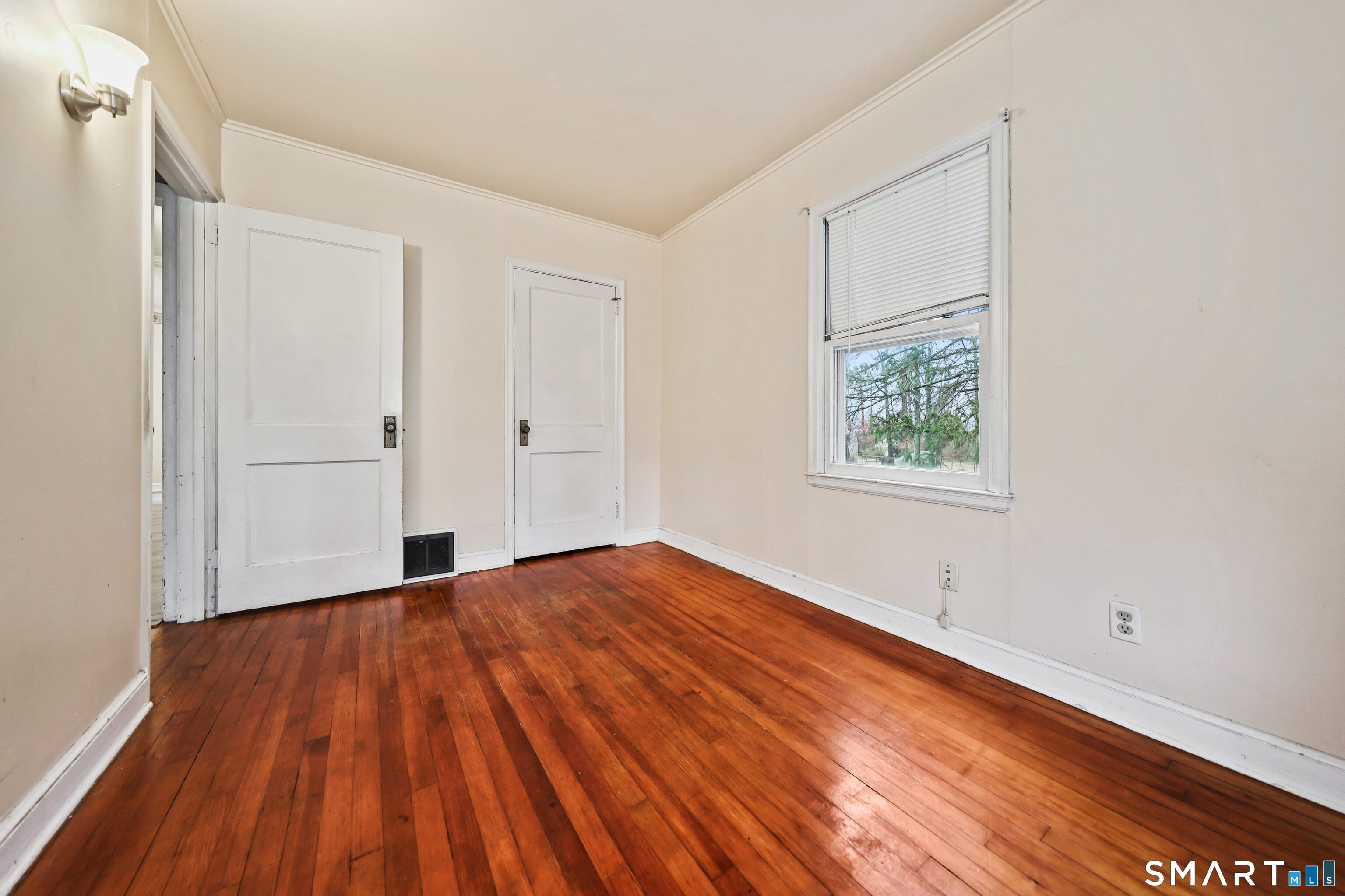 125 Tioga Street Torrington, CT 06790 - Photo 8 of 40 a view of an empty room with wooden floor and a window