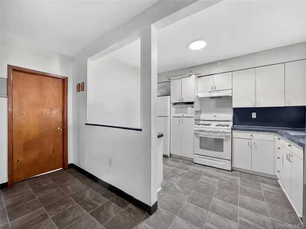 a kitchen with white cabinets and white appliances