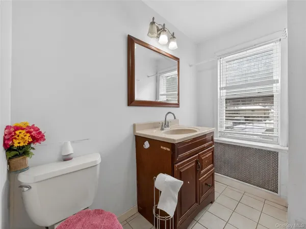 a bathroom with a toilet sink vanity and window