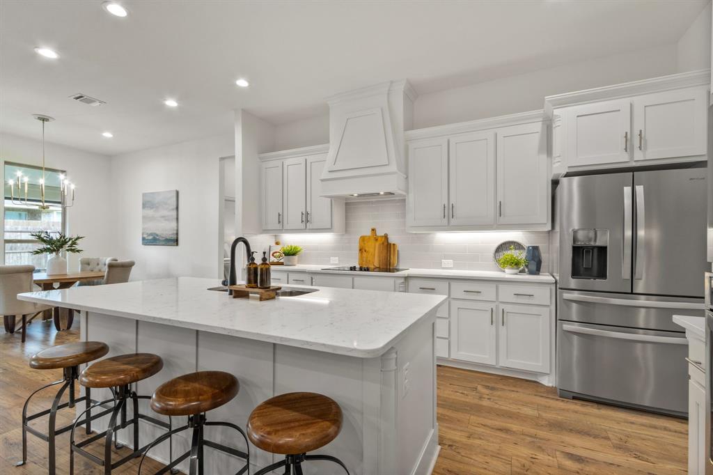 1625 Goodnight Trail Krum, TX 76249 - Photo 1 of 1 a kitchen with a sink a stove a refrigerator and white cabinets with wooden floor