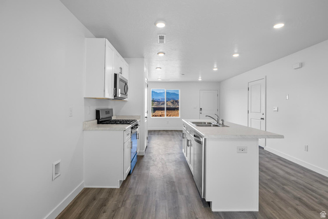 1597 South Fins Road, Unit 4177 Washington, UT 84780 - Photo 9 of 33 Modern kitchen featuring white cabinetry, light countertops, and stainless steel appliances, including a gas range and microwave