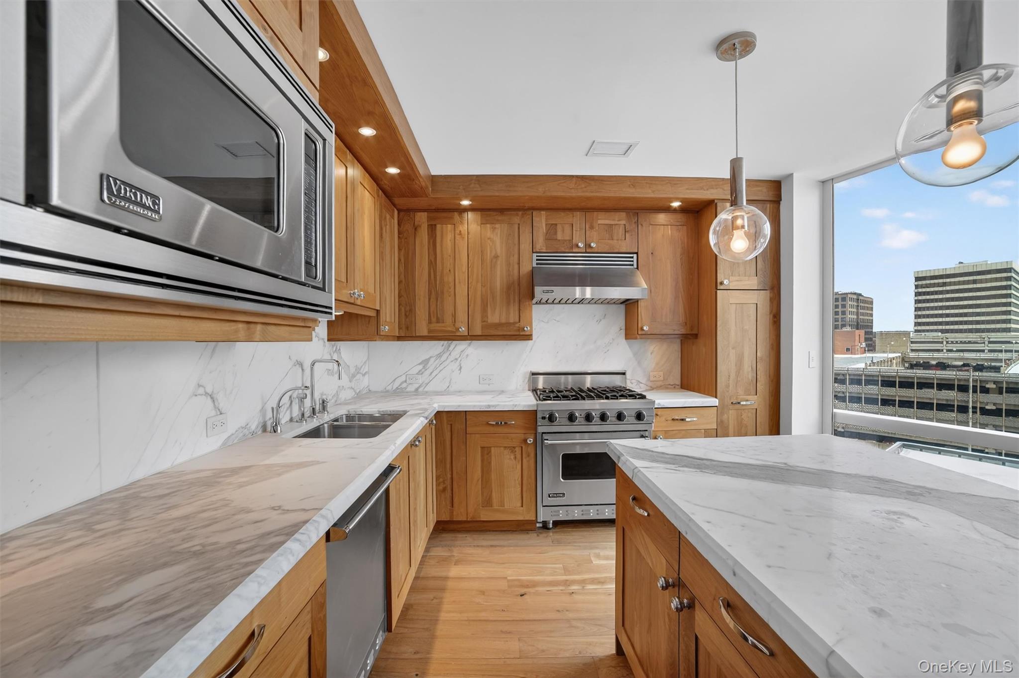 5 Renaissance Square, Unit 10G White Plains, NY 10601 - Photo 14 of 27 a kitchen with stainless steel appliances granite countertop a sink a stove and a wooden floors