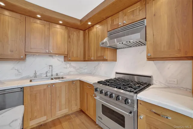 a kitchen with stainless steel appliances granite countertop a sink stove and cabinets