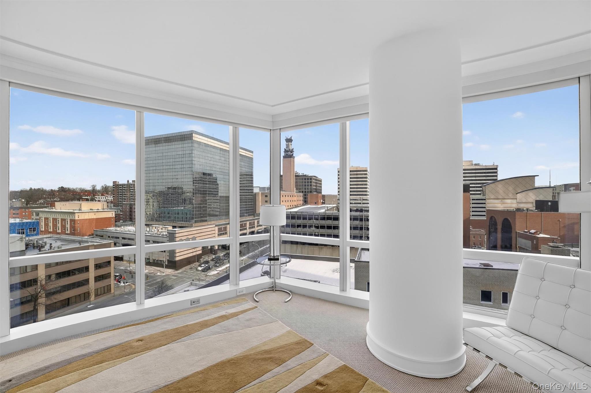 5 Renaissance Square, Unit 10G White Plains, NY 10601 - Photo 19 of 27 a living room with furniture a large window and wooden floor
