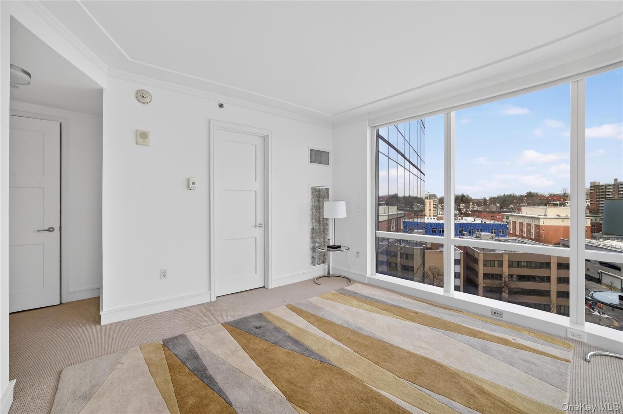 5 Renaissance Square, Unit 10G White Plains, NY 10601 - Photo 20 of 27 a view of a bedroom with a large window and city view