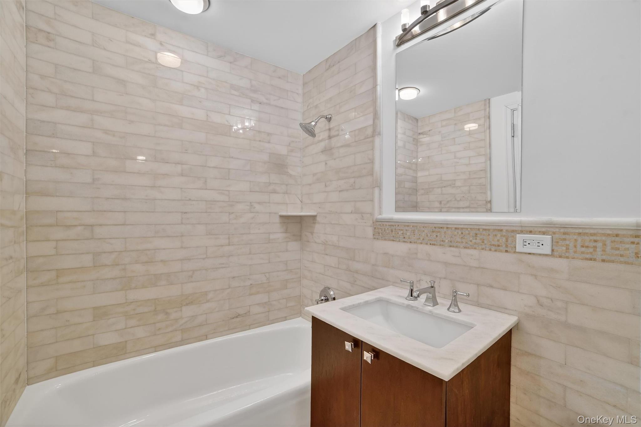 5 Renaissance Square, Unit 10G White Plains, NY 10601 - Photo 22 of 27 a bathroom with a sink mirror and a bathtub