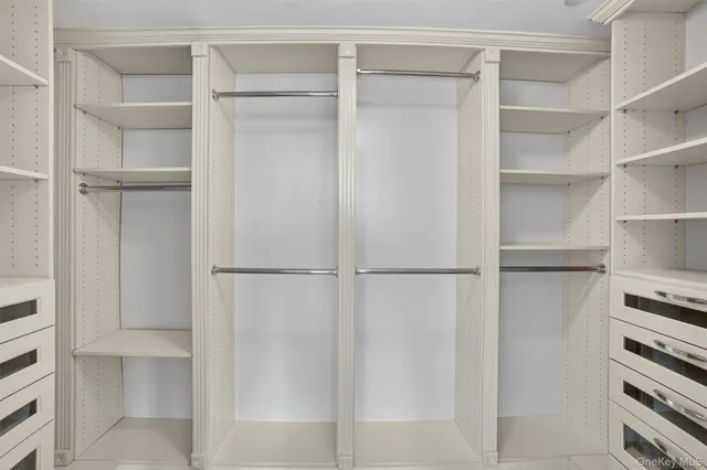 a view of walk in closet with empty racks