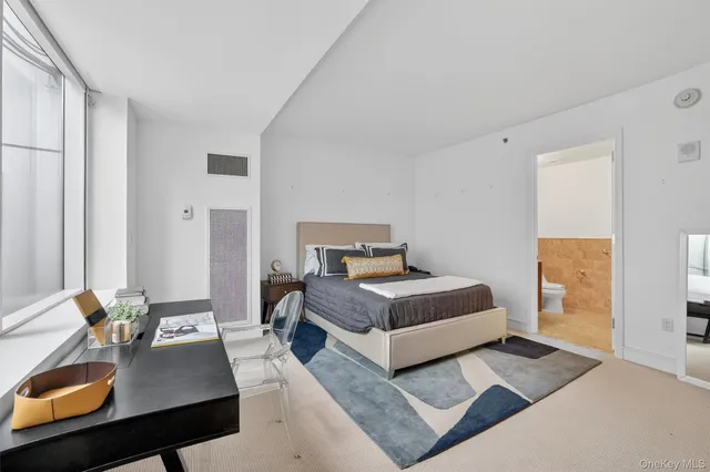 a bedroom with a bed table and a window