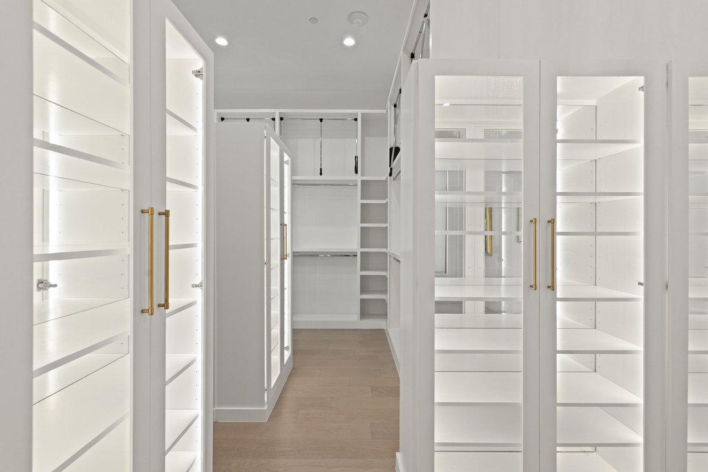 7117 Davenport Divide Road Austin, TX 78738 - Photo 25 of 40 An organized closet system with illuminated shelving and light-colored wood flooring offers ample storage solutions.