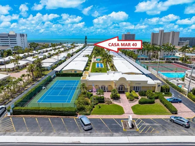 a group of people sitting on a park next to a building
