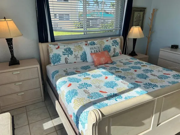 a bedroom with a bed and large windows